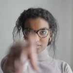 young ethnic woman pointing at camera