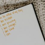 a notebook with encouraging quotes on a knitted fabric
